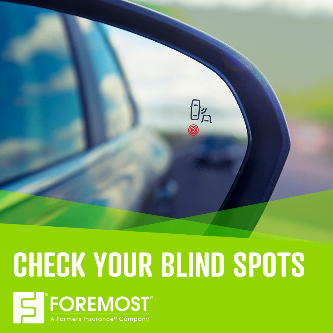 A car mirror with the blind spot sensor light on